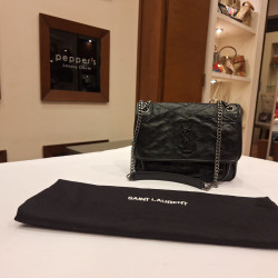 Black quilted Saint Laurent handbag with a chain strap and the YSL logo